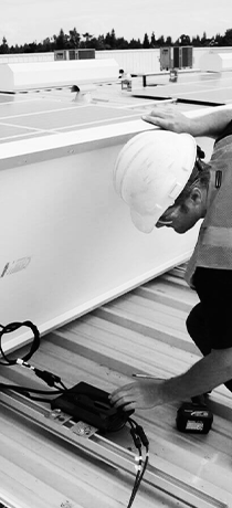 Worker installing solar panels on roof